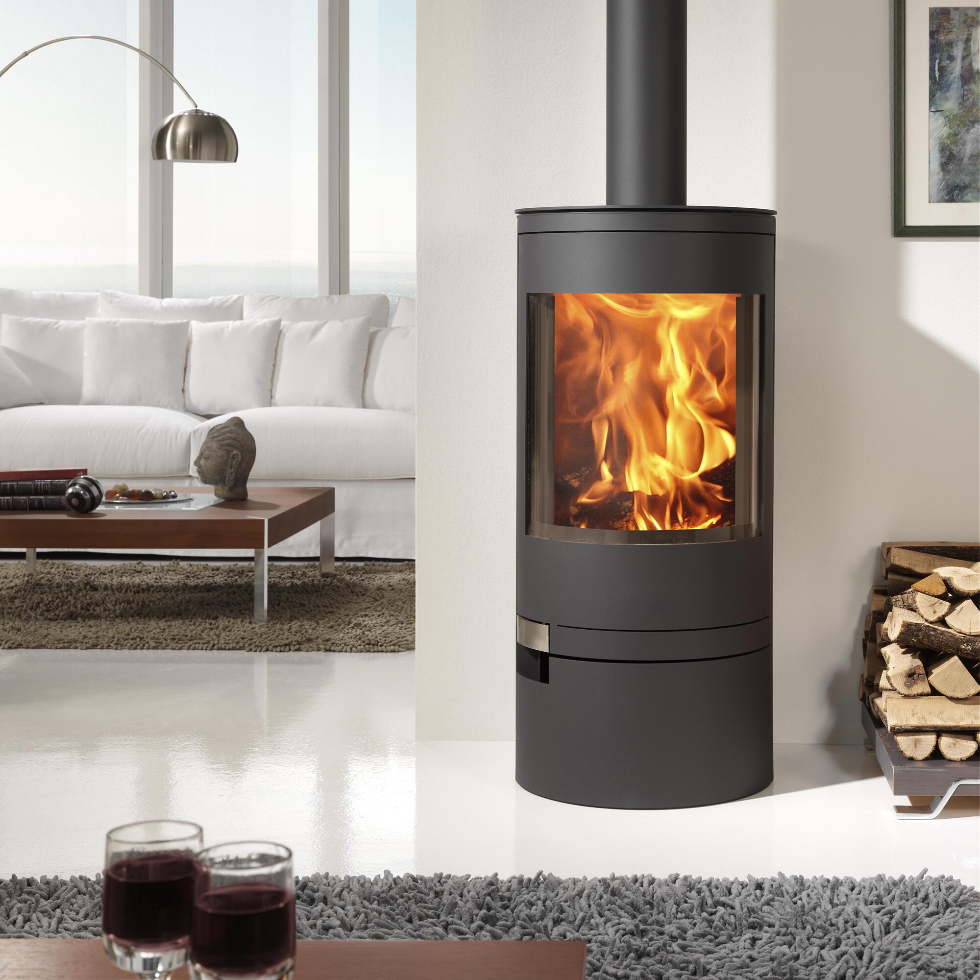 Modern cylindrical wood burning stove with a curved glass door