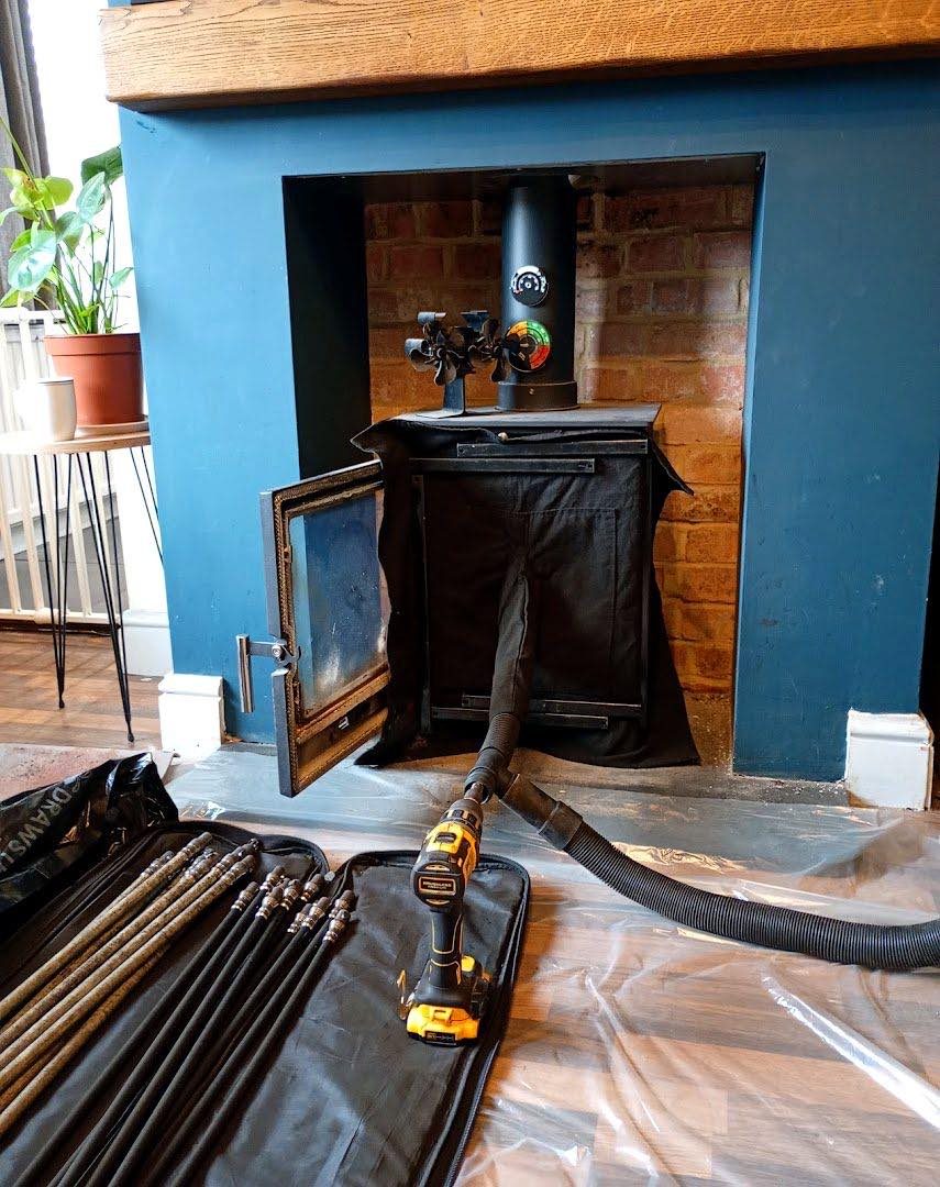Renovated fireplace alcove with a wood burning stove and stove fan
