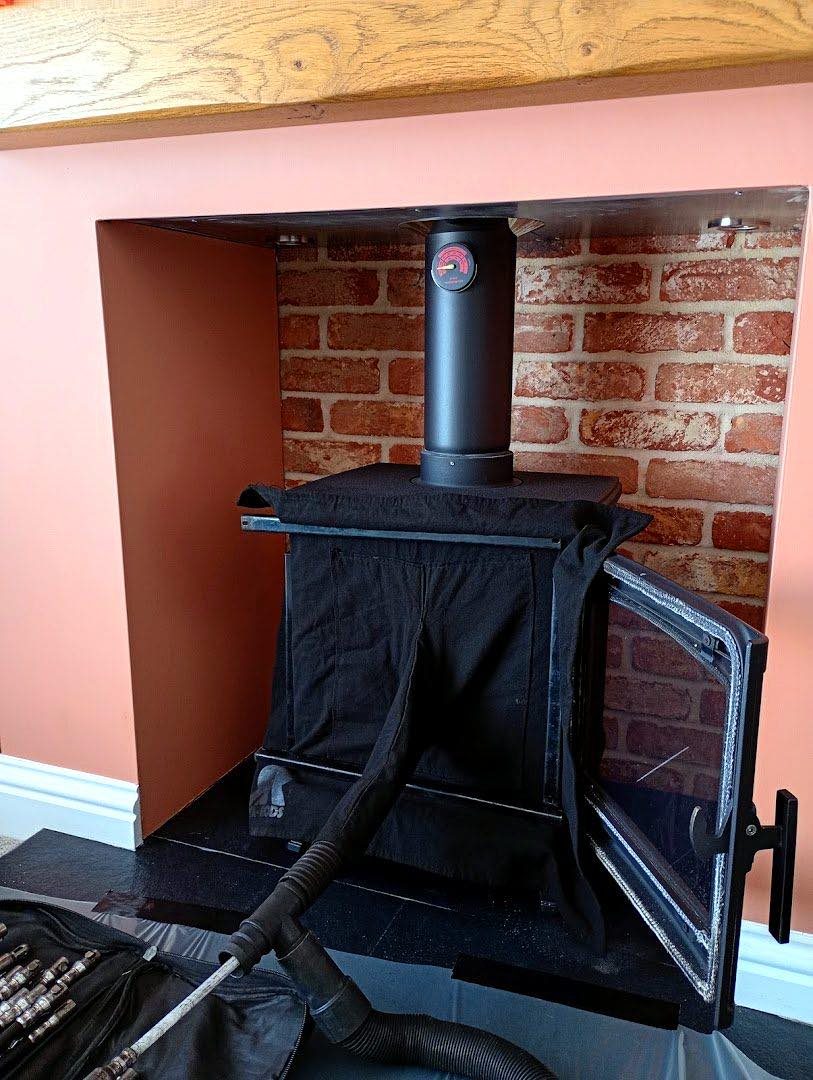 Wood burning stove fitted into a plastered fireplace alcove