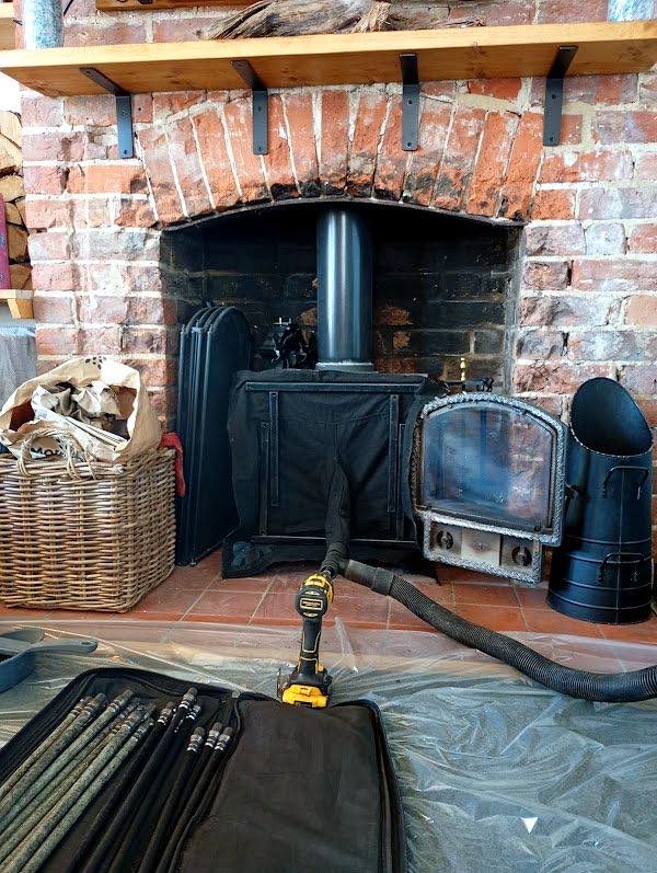 Sweeping rods and dust sheet laid out at a brick fireplace