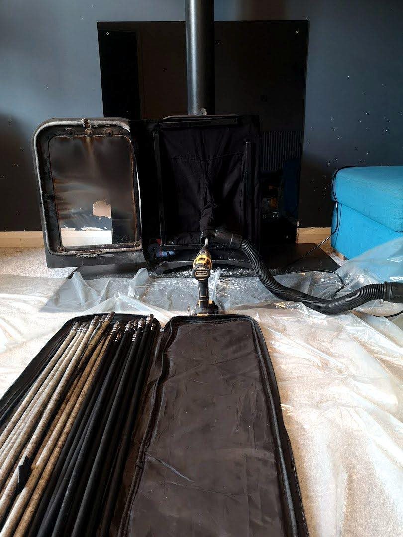 Stove being swept with vacuum and rods on a protective sheet